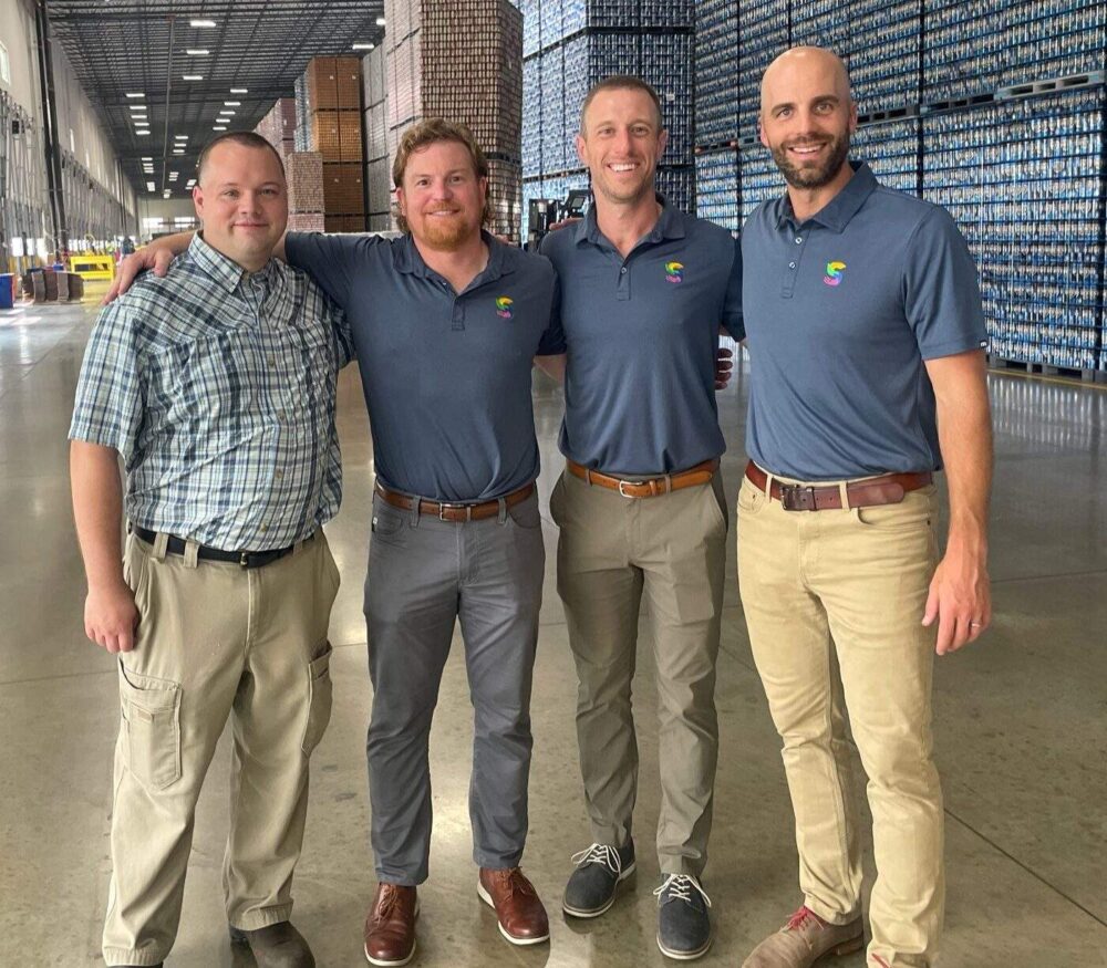 Four men standing in a warehouse