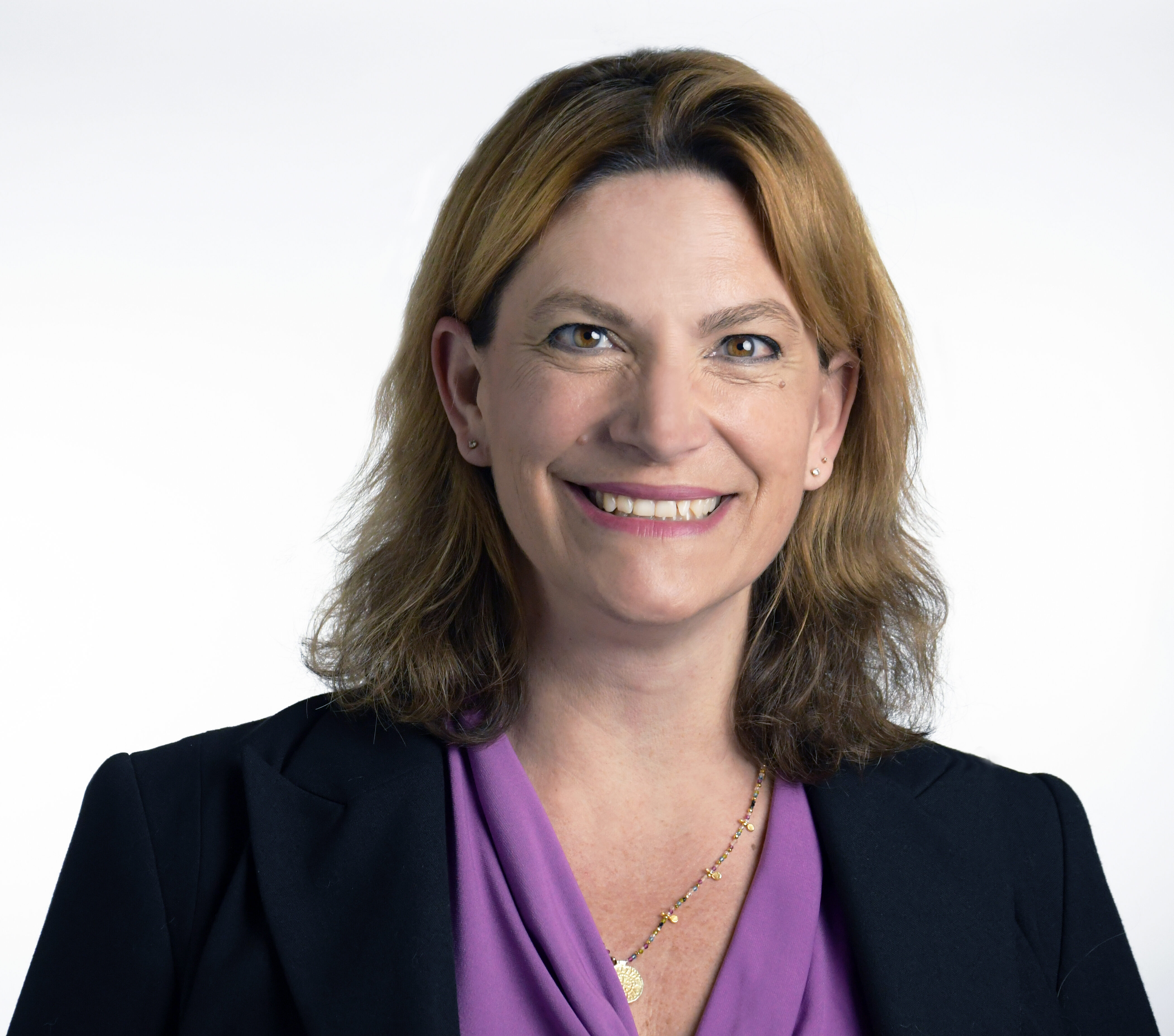 Headshot of woman in black blazer and purple top.