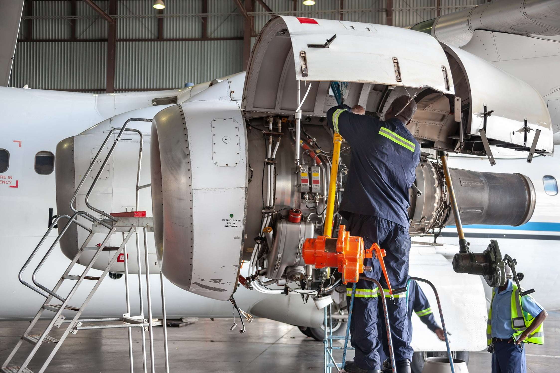 Mechanic working on plane engine.