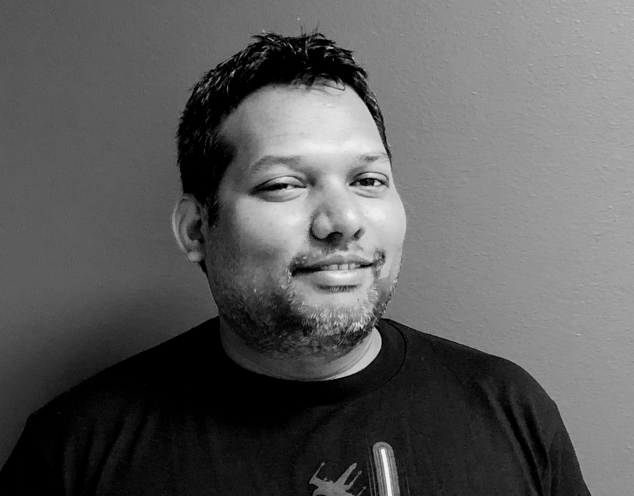 Headshot of man in black t-shirt.